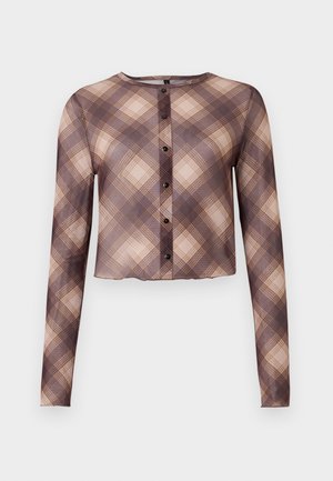 Cropped long-sleeve shirt in sheer fabric, featuring a beige and brown plaid pattern, round neckline, and black buttons down the front.
