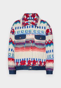 Chaqueta de forro polar con patrones geométricos coloridos en rojo, azul y crema, que presenta dos bolsillos de mezclilla azul y un cierre de botón.