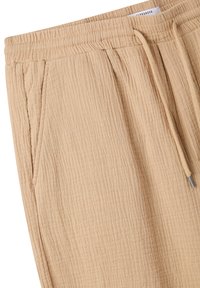 Pantaloni in cotone beige con texture, dotati di vita elastica, cordoncino e tasche laterali, caratterizzati da un delicato design stropicciato.