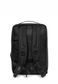 Musta reppu, jossa on teksturoitu kangas, pehmustetut säädettävät hihnat ja ylhäällä oleva kantokahva. Sisältää sivuvetoketjun ja logotarkin.