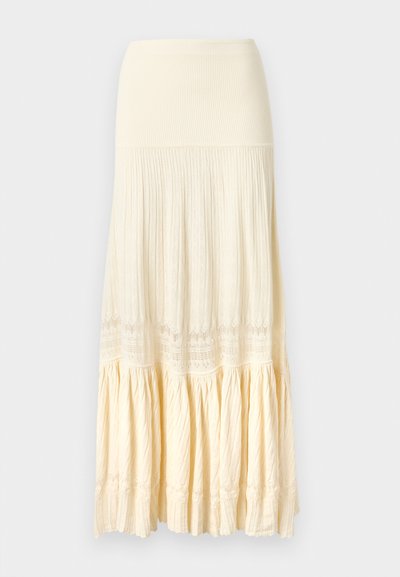 Langer cremefarbener Rock mit geripptem Bund, plissiertem Mittelteil und einem gerafften Saum mit dezenten Spitzenmustern.
