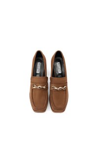 Mocassini in suede marrone con punta quadrata, dotati di una decorativa catena dorata sulla parte anteriore, texture liscia e soletta imbottita.