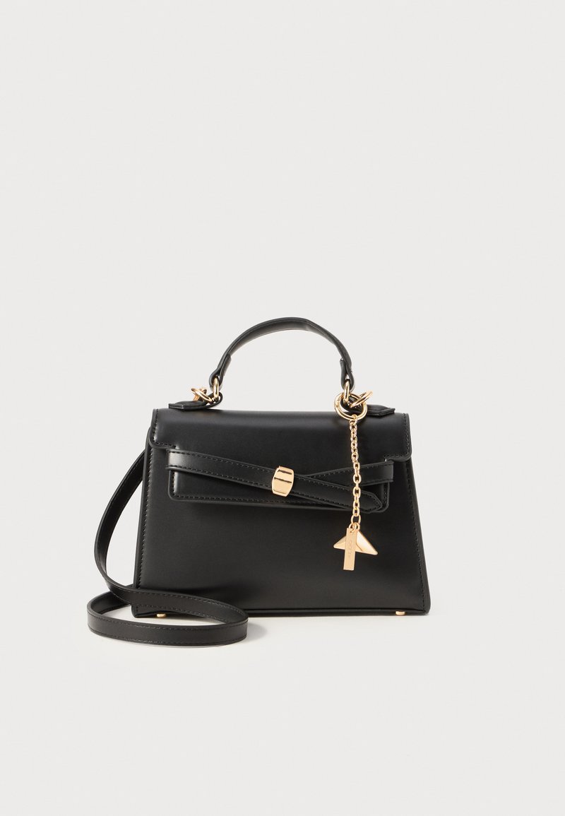 Black leather handbag with a structured design, gold hardware, bow detail on the front, and a detachable strap. Features a keychain accent.