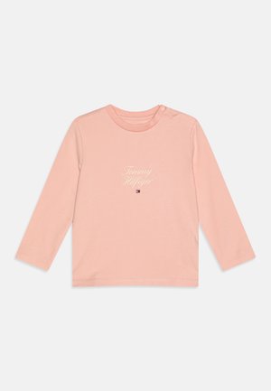 Lyserød langærmet t-shirt til småbørn med teksten "Tommy Hilfiger" og mærkelogo centreret under halsudskæringen samt trykknapper på skuldrene.