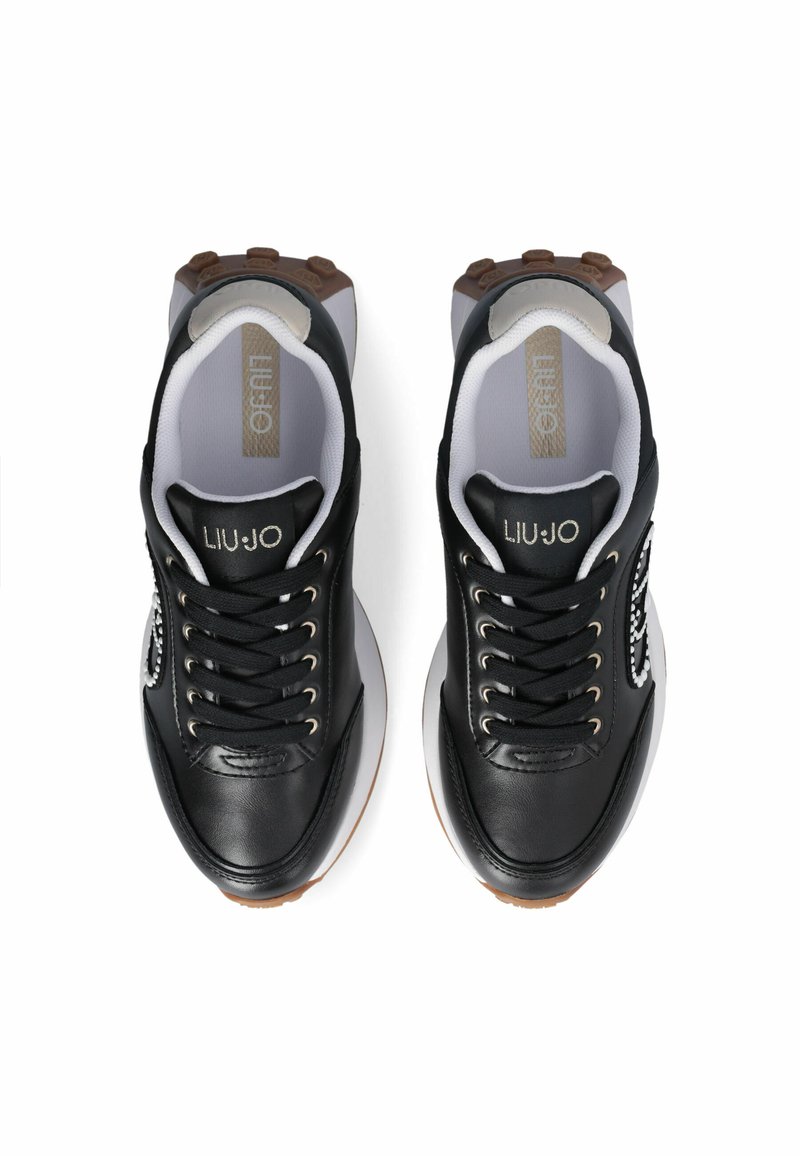 Chaussures de sport noires avec un dessus en cuir élégant, œillets en argent, semelles blanches et une semelle extérieure texturée marron. Logo "LIU JO" sur la languette.