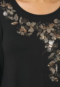 Top nero con motivo floreale realizzato in paillettes nei toni d'oro e argento, con scollatura rotonda e tessuto texturizzato.