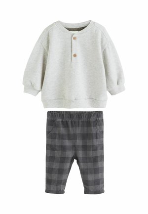Světle šedé dlouhé rukávy baby tričko se dvěma dřevěnými knoflíky v kombinaci s šedými károvanými kalhotami s elastickým pasem a kapsami.