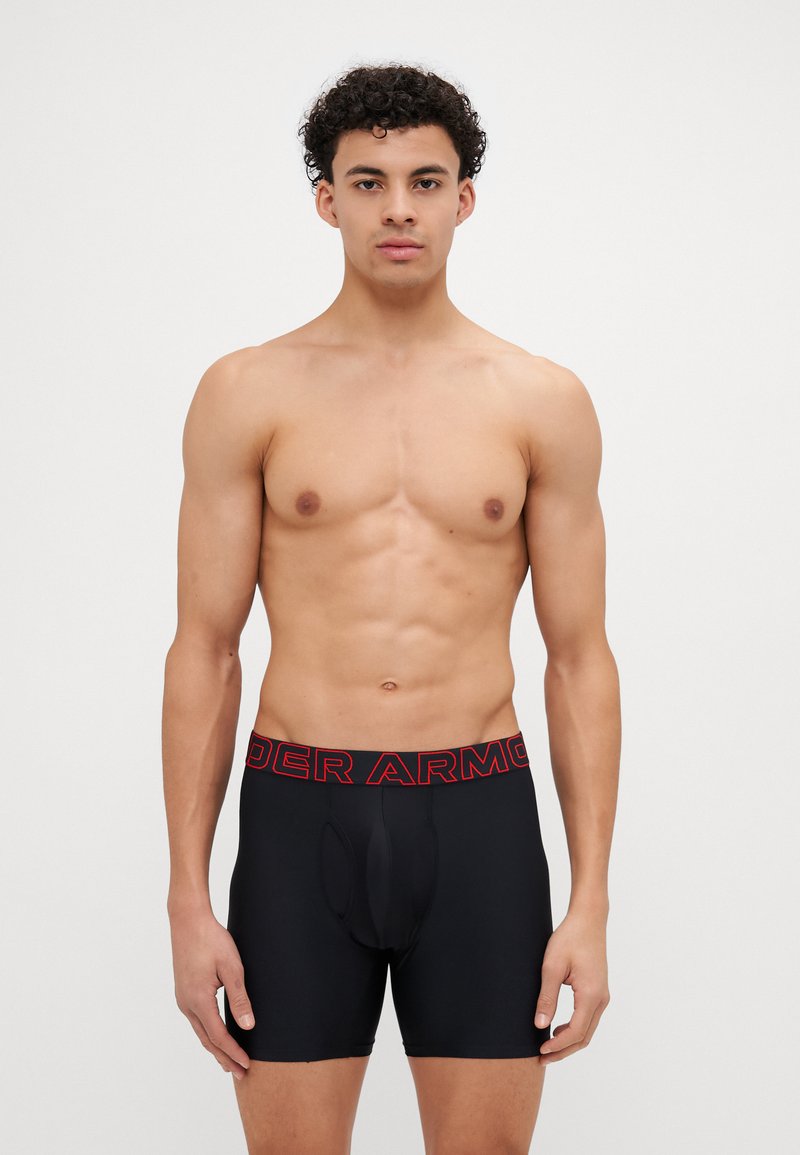 Boxeri negri, cu un logo roșu "Under Armour" pe talie. Materialul pare neted și elastic, proiectat pentru confort și potrivire.