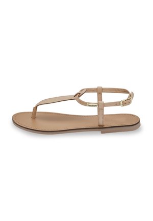 Sandales en cuir tan avec une semelle plate, une seule sangle pour les orteils, une sangle de cheville ajustable et des détails de boucle délicats.