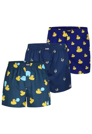 Tre par blå boxershorts med gule mønstre af gummidue og gråand, hver i varierende blå nuancer og andedesign.