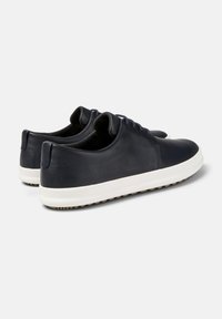 Sneaker in pelle blu navy con suola in gomma bianca, punta rotonda, design con lacci e dettagli testurizzati sul tallone e sul lato.