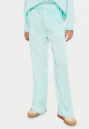 Light turquoise pants with a relaxed fit, elastic waistband, and soft texture, paired with beige and light tan shoes.