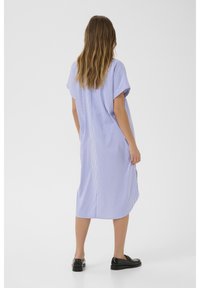 Abito midi a righe in azzurro chiaro e bianco, realizzato in tessuto leggero, con vestibilità rilassata, maniche corte e spacchi laterali per facilità di movimento.