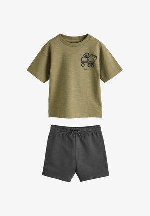 Olivo zelena majica kratkih rokavov z grafiko tovornjaka za izkopavanje in napisom »DIG IT!«, združena s kratkimi hlačami temno sive barve z elastičnim pasom.