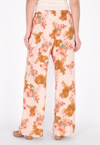 Blumenmusterweite Hose aus weichem Pfirsichstoff, mit einer Mischung aus orangefarbenen und braunen Rosen sowie grünen Blättern. Elastischer Bund und lässige Passform.