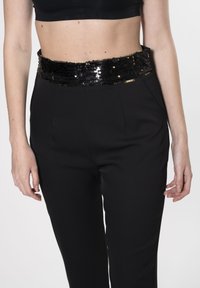 Zwarte broek met een aansluitend ontwerp, voorzien van een pailletten tailleband in zwart en goud. Gladde textuur met een gepolijste afwerking.