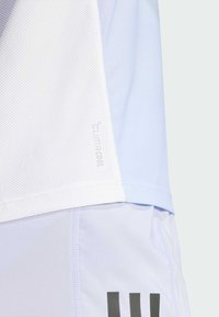 Camisa atlética de color azul claro con un diseño de malla transpirable, con el logo "Climacool" en el lateral y acentos en gris mate contrastantes.