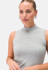 Top grigio senza maniche con collo alto, realizzato in tessuto a coste, con una silhouette aderente e una texture sottile, dall'aspetto liscio e morbido.