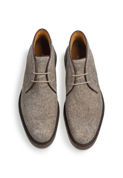 Pair of gray suede lace-up men's shoes with dark brown trim and light brown inner lining shown from above on white background.