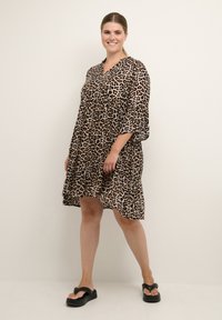 Leopard print dress with a V-neck, flared sleeves, and a tiered hem. Made from lightweight fabric, features a relaxed fit and knee-length design.