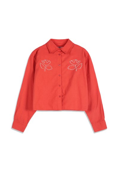 Chemise courte rouge à manches longues avec col, boutons sur le devant et broderie florale blanche en lignes sur la poitrine.