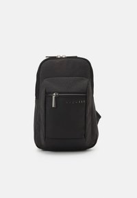 Zaino nero in un materiale liscio e strutturato, con una tasca anteriore con zip e un logo argentato sulla tasca.