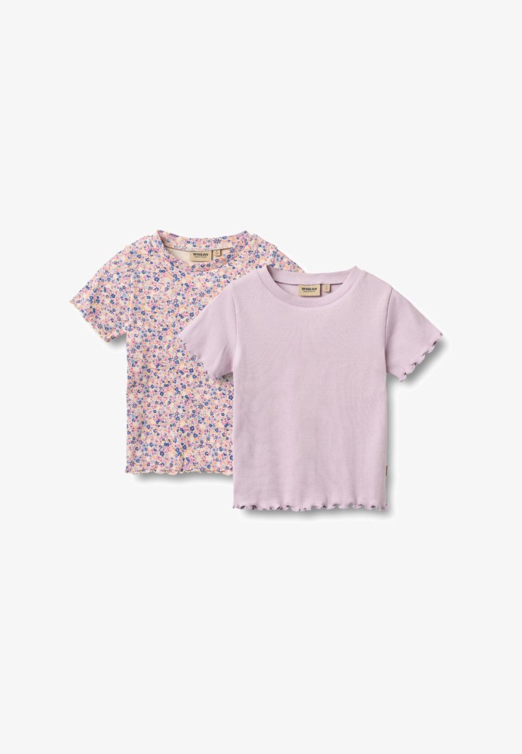 Zwei kurzärmelige Kinderhemden, eines einfarbig helllila und eines mit einem kleinen lila und pfirsichfarbenen Blumenmuster, beide mit Rüschen an den Kanten.