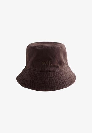 Brun bomulds bucket hat med syet skygge og ordet "self." broderet med matchende tråd på forsiden.