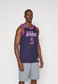 Ljubičasta košarkaška dres sa "Vukovi" i brojem "5" u rozoj boji, sa teksturiranim dizajnom ramena. Uparen s sivim sportskim šortsevima.