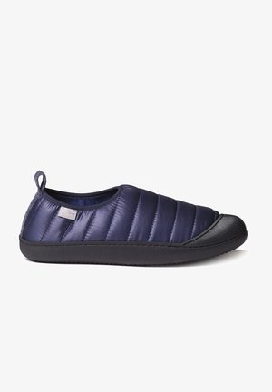 Polstret marineblå slip-on sko med en struktureret sort gummisål, der har quilted detaljer og en bageste træksløjfe for nem påtagning.