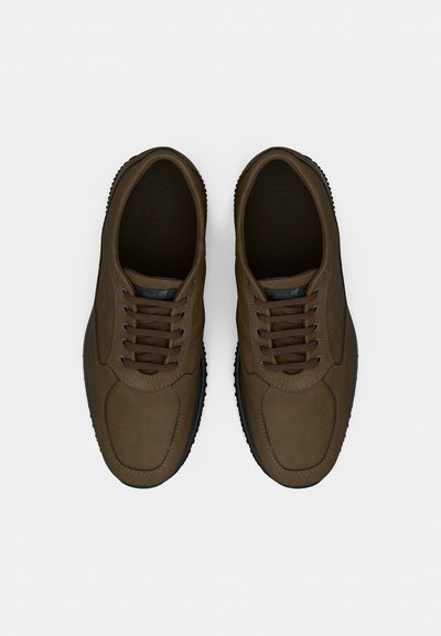 Rudi odiniai sportbačiai su apvalia nosimi, plokščiais raišteliais ir tekstūruota gumine sole. Lygus paviršius su subtiliomis siūlų detalėmis.