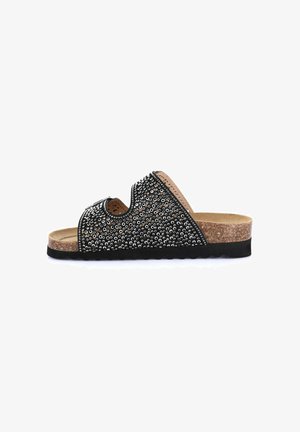 Sandalo nero slip-on con due cinturini con borchie argentate, soletta in sughero e suola in gomma nera, vista laterale.