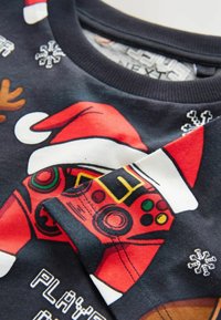 Czarna bluza z kapturem z czerwoną grafiką w świątecznym stylu, przedstawiającą kontroler do gier, czapkę Mikołaja, płatki śniegu oraz detale ozdobne w postaci reniferów.