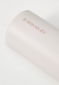 Insulated tumbler in matte light pink finish with a smooth texture. Features a "STANLEY" logo in light pink on the side.