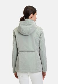 Light gray, hooded jacket with a fitted design, smooth texture, and contrasting stitching details. Features a waistline accent.
