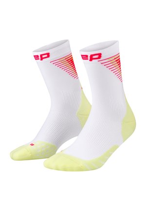 White athletic socks with yellow toes and heels, featuring red geometric design and text near the top cuff.