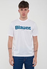 T-shirt bianco in cotone a maniche corte, con la scritta teal "Blauer." e un sottile dettaglio "USA" sottostante. Design classico a collo tondo.