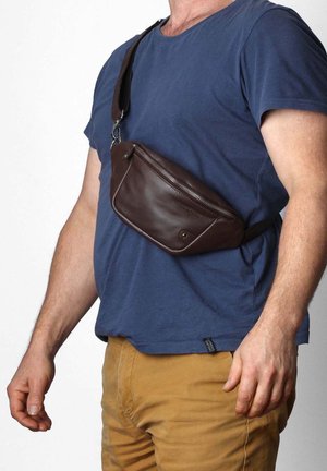 Brown leather fanny pack with a zippered compartment, sleek design, and an adjustable strap worn across the torso. Matte finish with soft texture.
