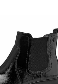 Botin din piele lăcuită neagră până la gleznă, cu panouri elastice pe lateral și buclă pentru a fi tras. Botinul are o textură netedă și elegantă, cu un hardware minimal.
