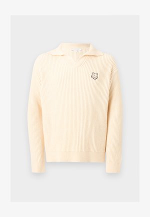 Roomkleurige ribgebreide trui met een kraag en een klein logo van een wolfskop op de linkerborst.