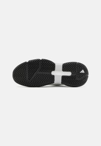 Černá gumová podrážka s rybí kostí a bílou mezipodrážkou. Výrazné logo Adidas na patě a strukturovaný grip pro lepší přilnavost.