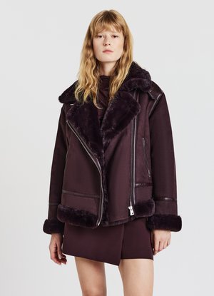 Giacca di shearling bordeaux con colletto in pelliccia sintetica, chiusura con zip e dettagli a contrasto. Presenta una vestibilità comoda e una texture morbida.