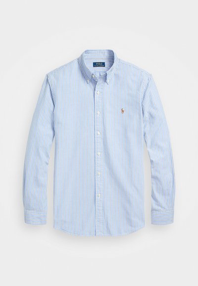 Heledast sinine nööpidega särk, millel on vertikaalsed valged triibud, pikad varrukad ja väike punane tikitud logo rinna peal. Puuvillane kangas, kraega disain.