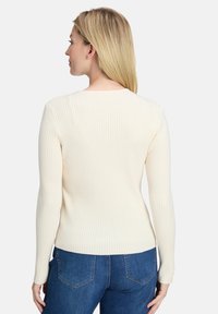 Cremefarbener, gerippter Pullover mit langen Ärmeln und rundem Ausschnitt, der eine figurbetonte Silhouette und eine glatte Textur aufweist.