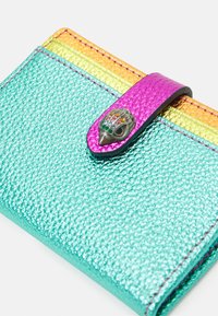 Gestructureerde teal portemonnee met een roze drukknoopsluiting, gekenmerkt door een decoratief handontwerp en een verloop van oranje-gele accenten aan de bovenkant.