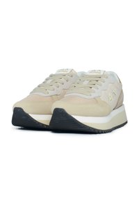 Sneaker beige con una toma in mesh e scamosciato, chiusura con lacci, intersuola bianca, suola in gomma nera e dettagli con logo sulla linguetta e sul lato.