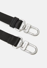 Cinghie in nylon nero con clip in metallo argentato, caratterizzate da una finitura testurizzata e da un dettaglio hardware con logo. Design durevole e funzionale.