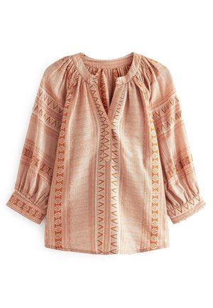 Blouse rose clair avec des rayures géométriques verticales orange, encolure froncée et manches trois-quarts bouffantes avec poignets boutonnés.