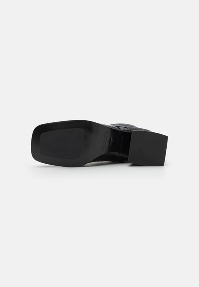 Chaussure à talon noir avec un bout carré et un talon bloc. Dispose d'un matériau supérieur lisse et d'une semelle texturée pour une meilleure adhérence.
