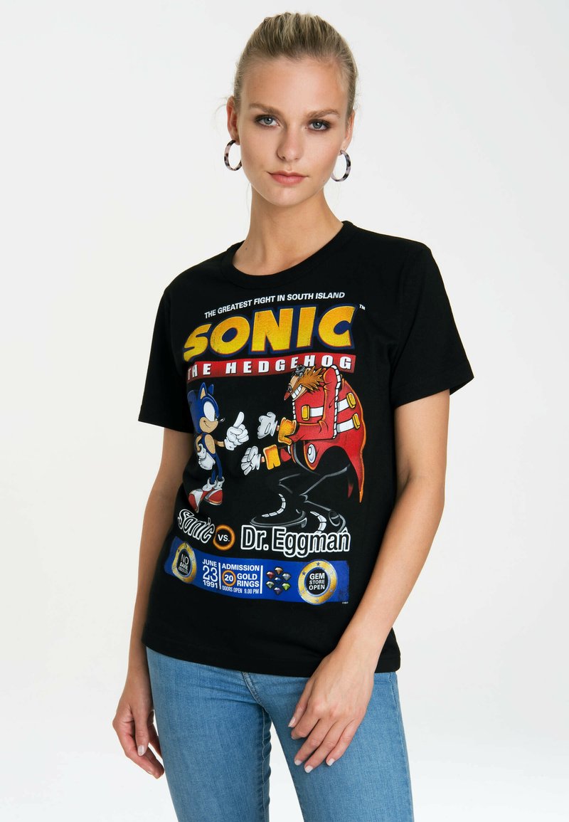 Black cotton t-shirt featuring colorful Sonic the Hedgehog graphics, short sleeves, crew neckline, and a vibrant printed design with event details.